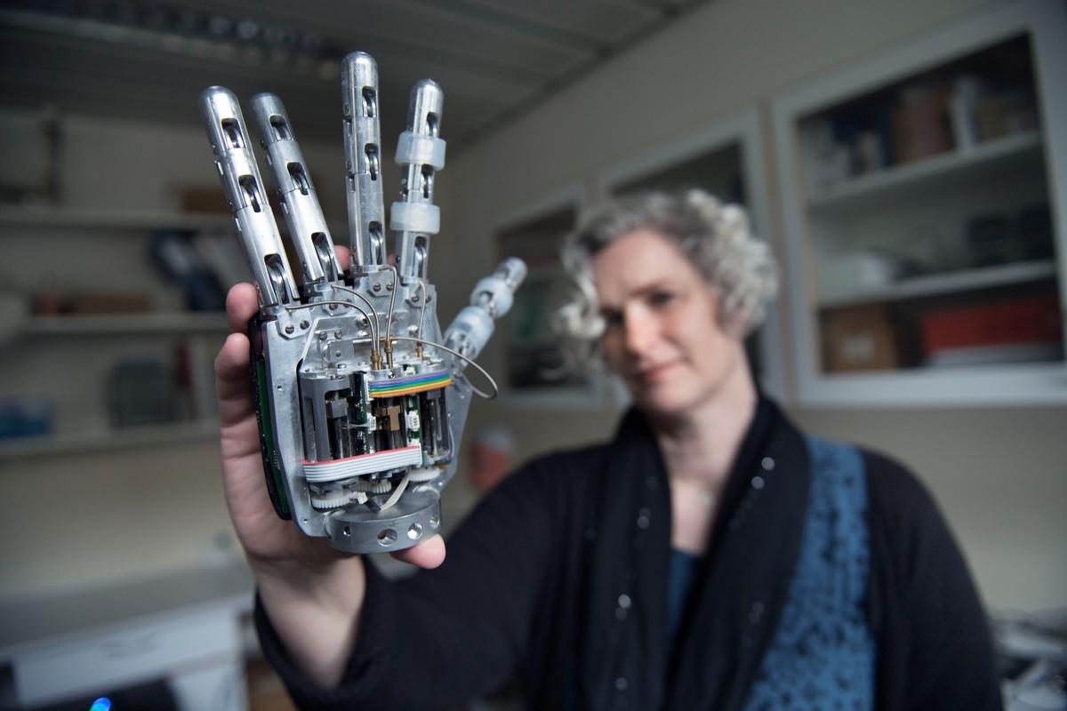Lotte Struijk holding a robot hand
